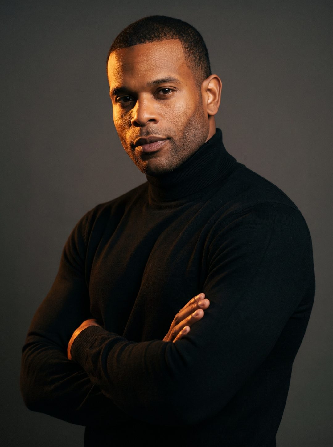 Studio portrait of onlythesexy in a black turtleneck under moody lighting